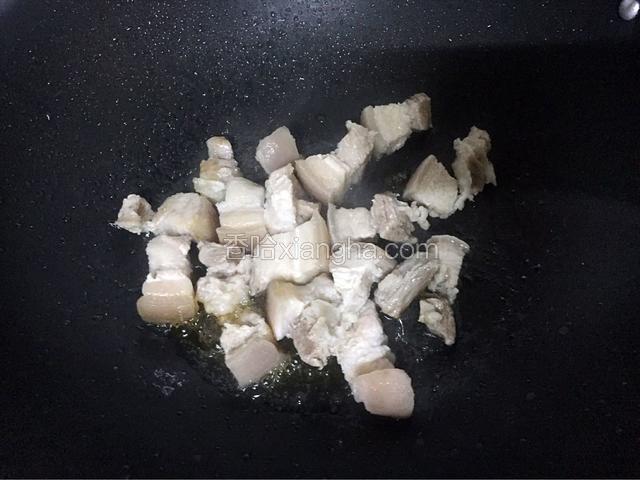 放入五花肉翻炒至裹上糖色