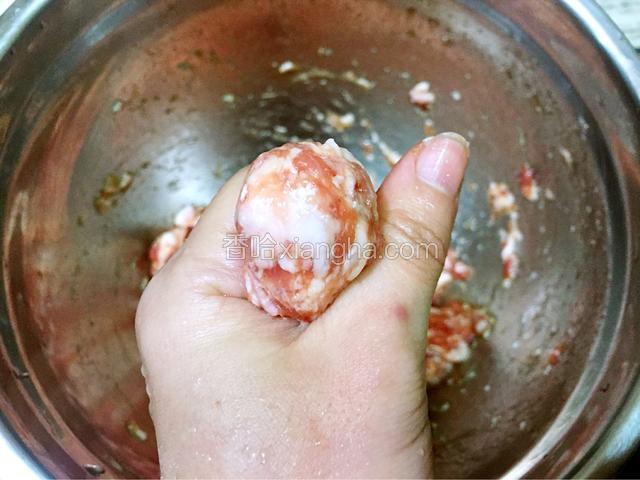 手沾水后把肉蓉放入手心里，然后用虎口挤出丸子形状