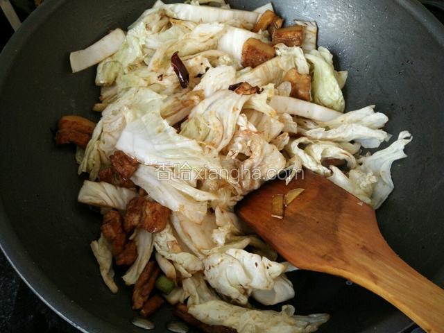 接着放大白菜叶进去，翻炒均匀，炒到白菜炒软
