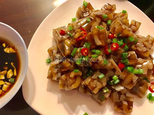 另取一碗，加入生抽、醋、香油和蒜末调成蘸料。肉皮冻上撒上葱花和红椒末点缀一下。
