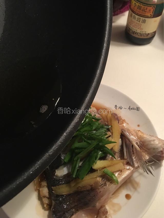 撒上葱丝，热油锅，将烧热的油均匀淋在鱼头上