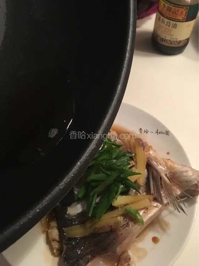 撒上葱丝，热油锅，将烧热的油均匀淋在鱼头上