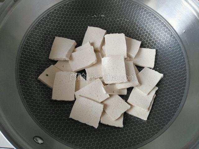 热油下豆腐片，小火煎豆腐片。