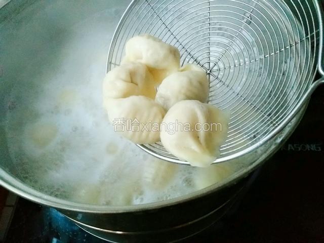 拿起锅盖，再煮2-3分钟即可，饺子煮至鼓肚就是熟了，用漏勺捞出饺子就可以吃了。