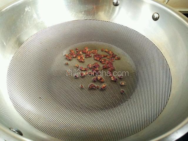 炒锅中加入适量食用油，小火煸香花椒，然后将花椒去除不用。