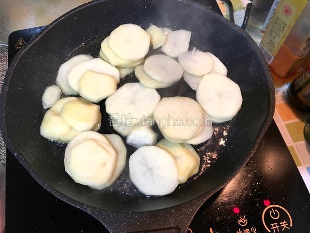 热锅放油，倒入土豆片