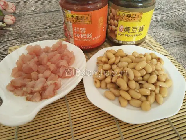 准备好李锦记蒜蓉辣酱和黄豆酱。猪瘦肉切成小粒，和煮熟的黄豆一份，黄豆的煮制方法就是提前一夜泡发，然后加盐煮半个小时就可以。