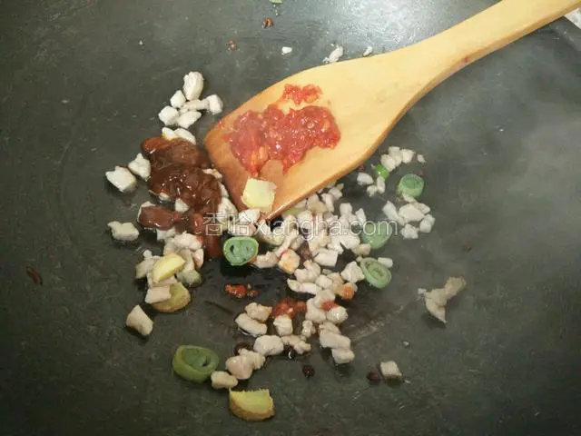 炒到肉出香味，而且颜色发白时放入李锦记黄豆酱和蒜蓉辣酱。翻炒均匀。