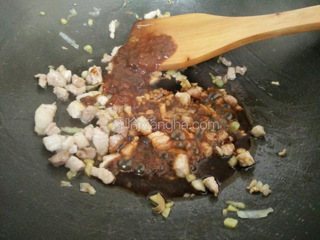 把肉末放进锅里炒到变色发白时，加李锦记黄豆酱，加李锦记酱油炒匀'