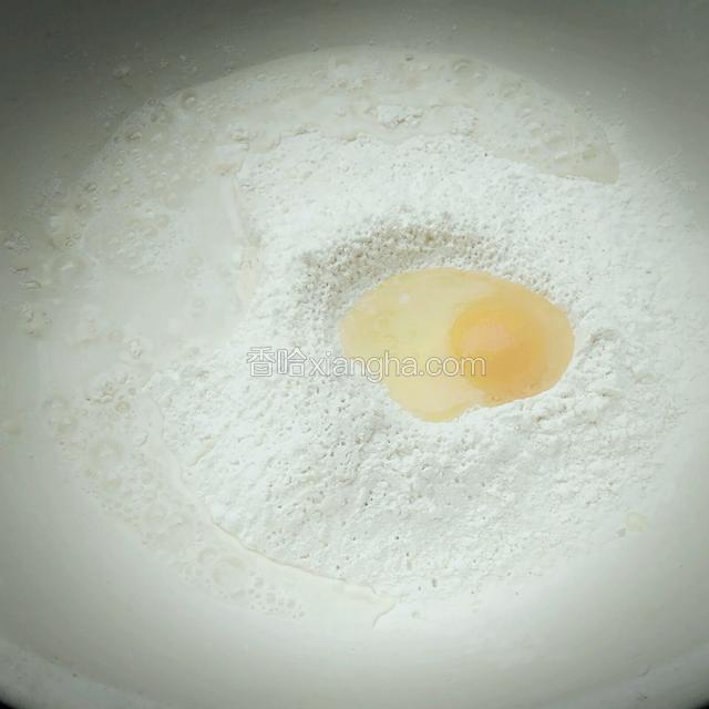 面粉倒入面盆，磕入鸡蛋打散，加适量清水。