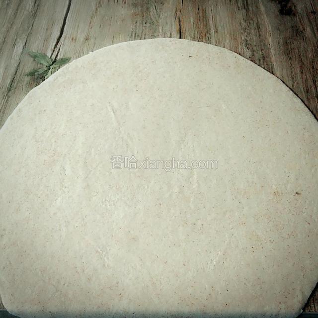 面醒好了，用擀面杖擀成一个大的薄面片。