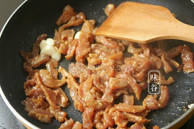锅内热油，倒入蒜爆香后倒入肉丝翻炒。