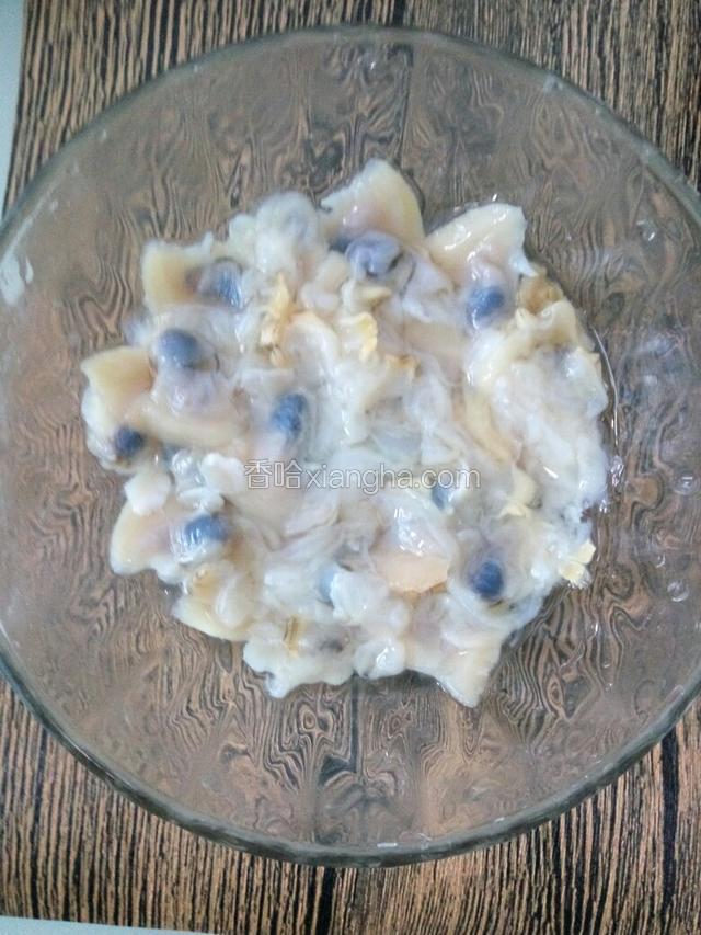 铲出文蛤肉，用洗菜篮在水池中顺方向搅拌几百次，洗去沙子
