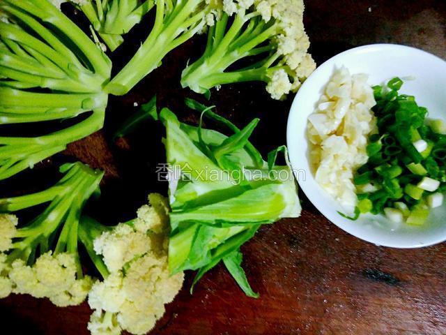花菜切成小棵棵，大蒜和葱切碎。