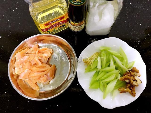 食材备用。西芹洗净、撕去老筋，切成细长菱形状备用。鸡肉切成长条状，加适量料酒和盐腌制20分钟。核桃仁掰成两半。