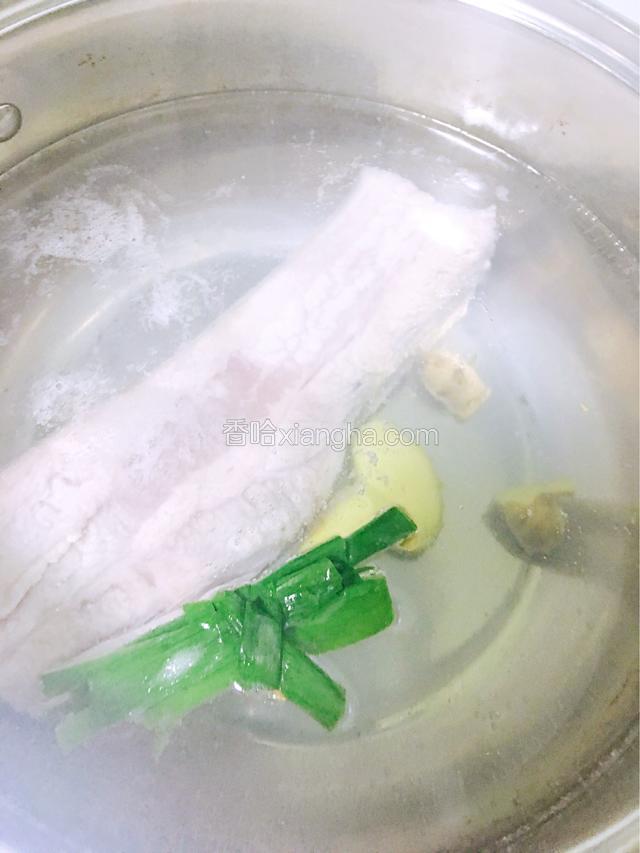 锅中烧开水，放入五花肉、姜和葱段一起煮至八成熟。