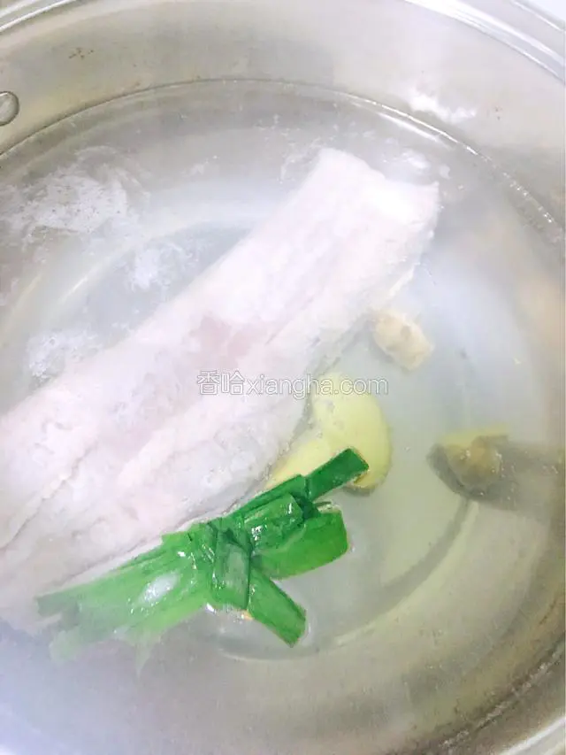 锅中烧开水，放入五花肉、姜和葱段一起煮至八成熟。