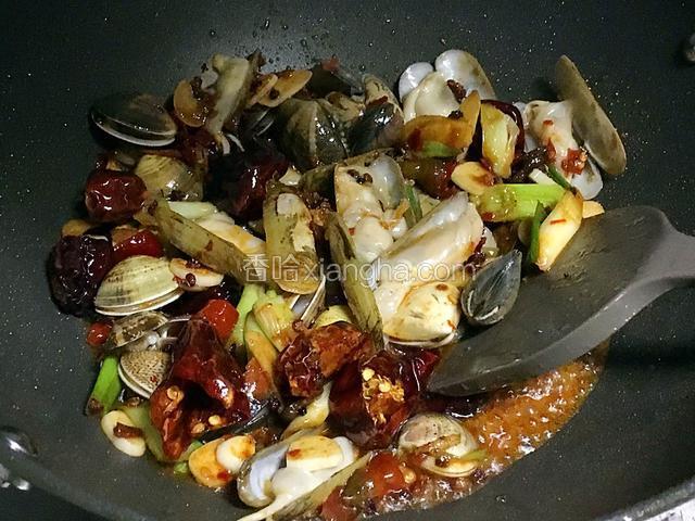 倒入蛏子翻炒,加入少许的酱油、料酒、鸡精,砂糖几颗