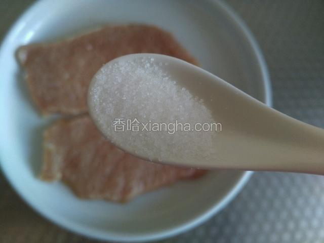 然后把肉片放进一个盘里，先放盐和黑胡椒碎。
