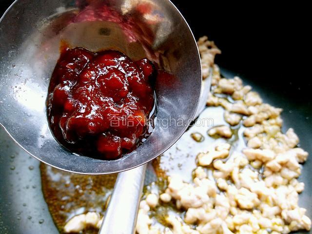 然后把李锦记辣黄豆酱适量倒入锅内