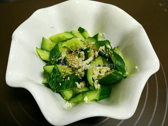 黄瓜上撒上芝麻和蒜末。