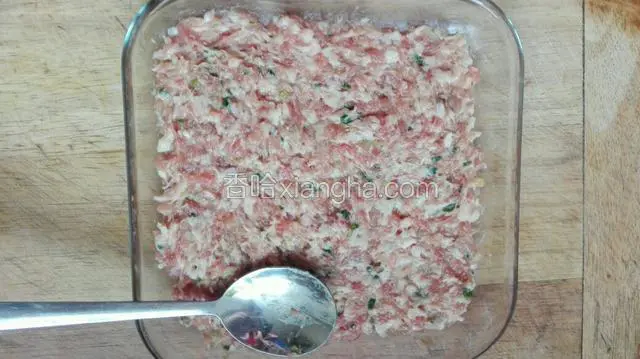 用勺子将肉馅均匀的，铺在平底盘子中。