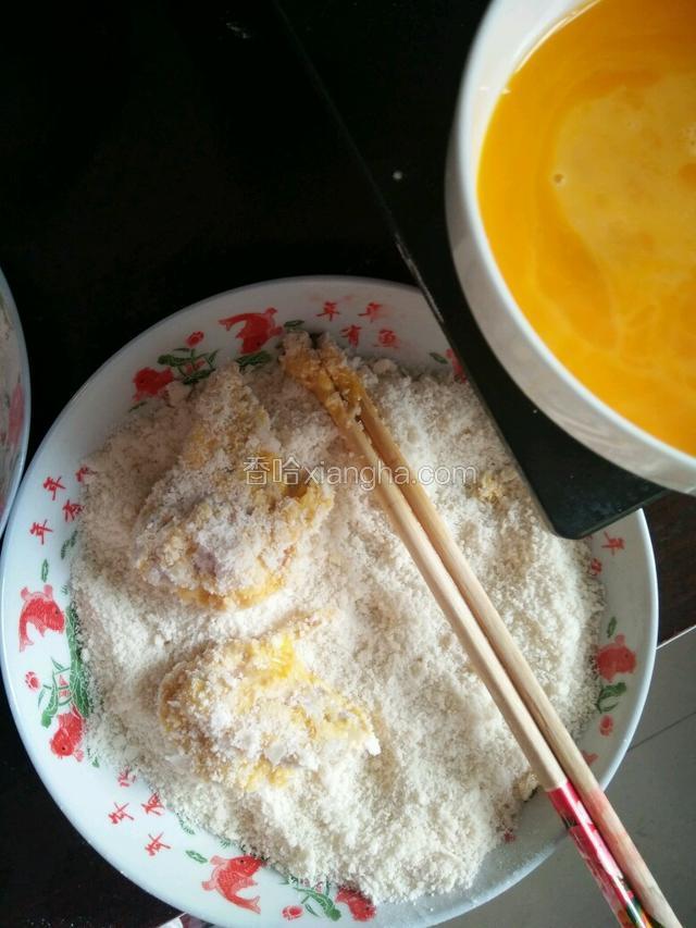 蛋液裹均匀以后，再把鸡叉骨放到面包康里滚下，可以用手按下面包康，这样炸的时候不容易掉。（我家里没有面包康了，我用的馒头屑）