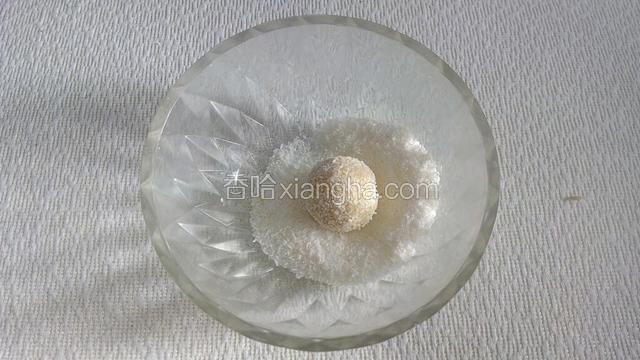 将它放入盛有剩余椰蓉的碗中滚一滚，让面球沾满椰蓉。一个椰蓉球胚子做好了。