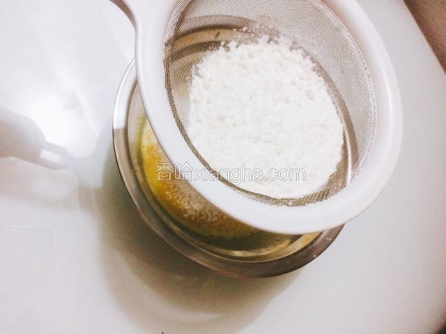 筛入低筋面粉，用刮刀快速地翻拌均匀，然后放到一边静置。开始上下火150度预热烤箱。