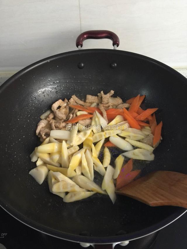 加入竹笋，胡萝卜，盐继续翻炒。
