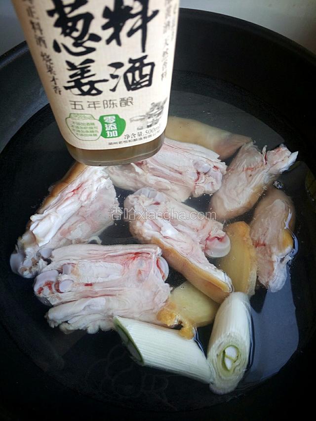 锅内倒入冷水放入切好的猪蹄、姜片、葱段再倒入料酒。