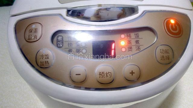 将泡好的绿豆放入电饭煲，加入适量清水（水没过绿豆一点点），盖上电饭煲盖，按下蒸煮功能的键，开始煮绿豆。