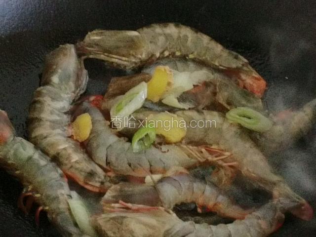 热油下锅，将大虾一只只摊开放入热油中，中小火煎炸；