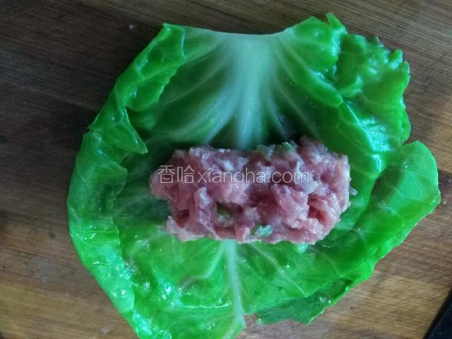 取一片菜叶，放入适量肉馅