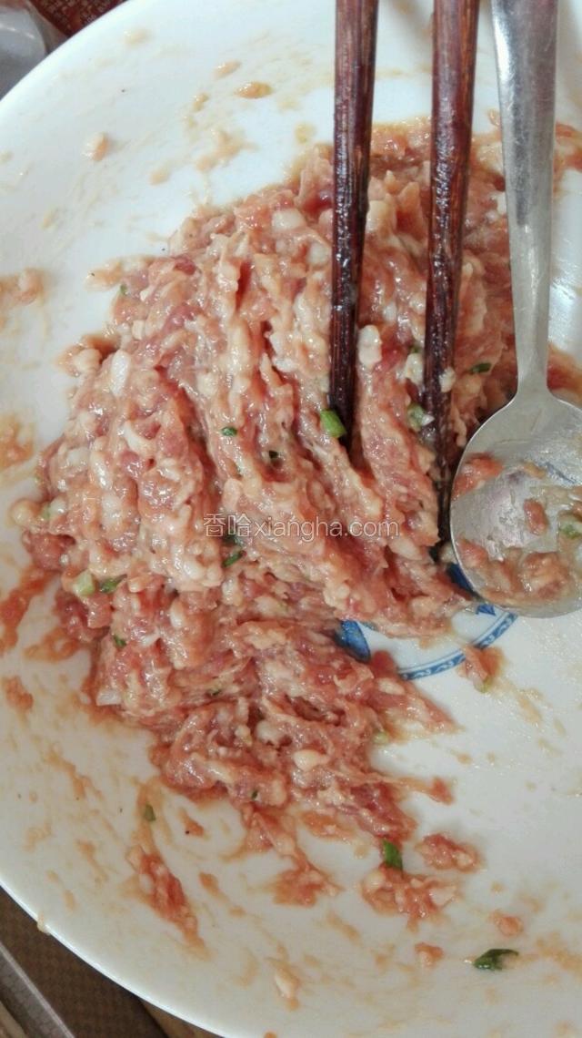 猪前腿肉打成肉馅后，加入一个鸡蛋、盐、糖、生抽、料酒、胡椒粉、十三香、香油、姜汁和葱末用筷子顺时针朝一个方向打上劲（肉馅打上劲就是打的过程中筷子阻力越来越大，感觉越来越粘稠，肉馅在碗中倒扣碗，肉馅不掉落）这个过程中要加入三次水，加水总量为二十克，每次都要将水完全吸收入肉馅中。