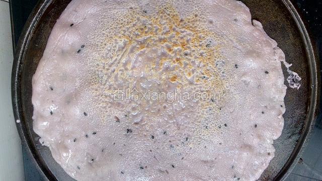 小火煎，至面糊变色并微微鼓起，翻面，继续煎另一面，如图。