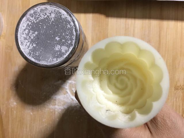 月饼模上撒上面粉，嗑掉多余的面粉；；