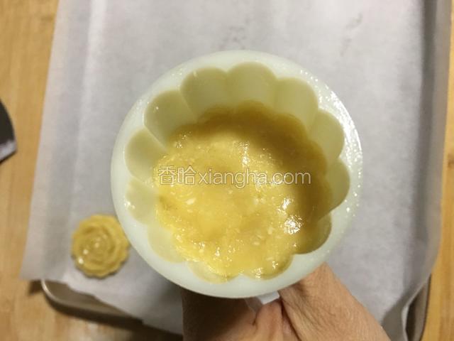 取一个20克的小面团放入月饼模中，用母指压实；