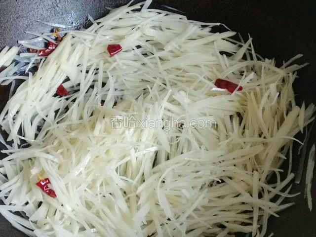 下入土豆丝加少许盐煸炒三分钟；