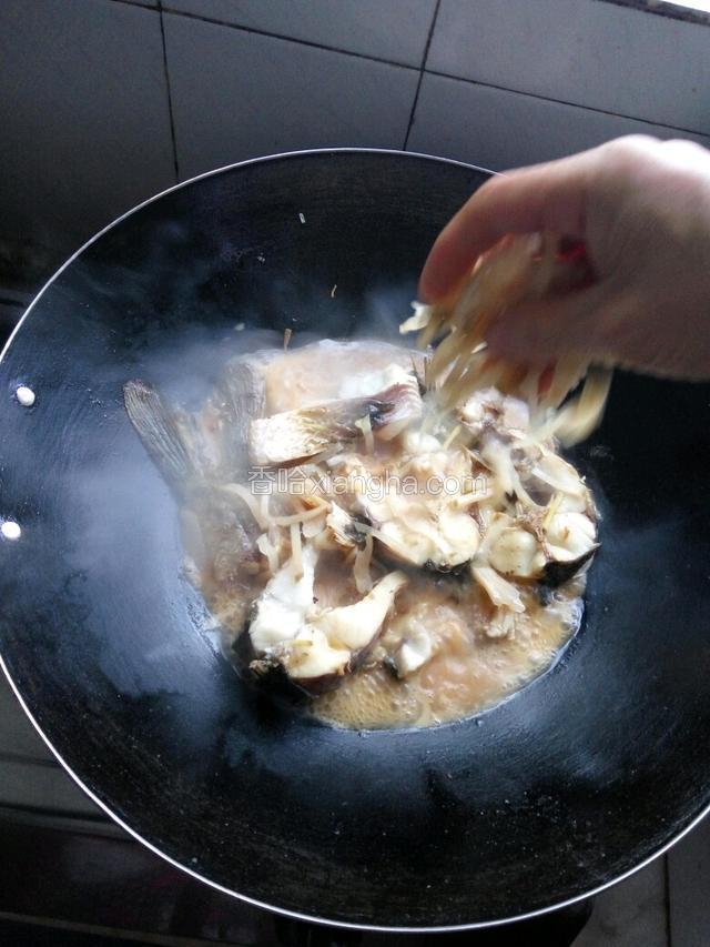 撒入大头菜丝，大火煮，盖上锅盖煮至可以轻易用筷子戳入鱼肉