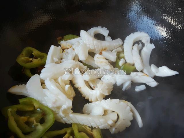 倒入鱿鱼圈翻炒，调入料酒，白糖翻炒一会！