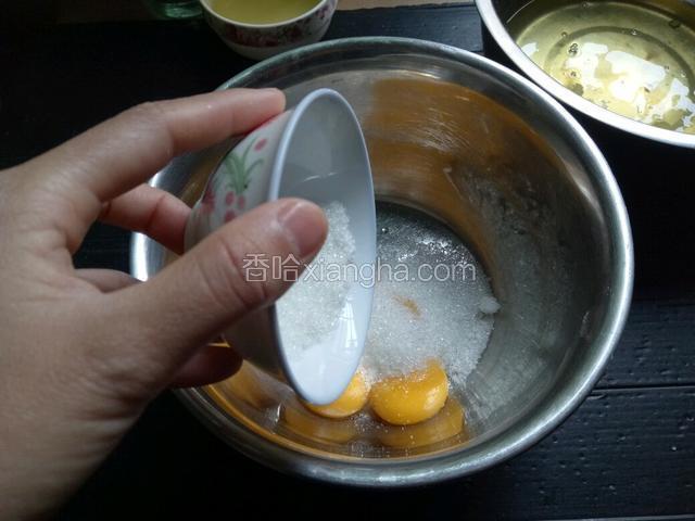 将30克白糖倒入蛋黄中，用手动打蛋器打至白糖融化。