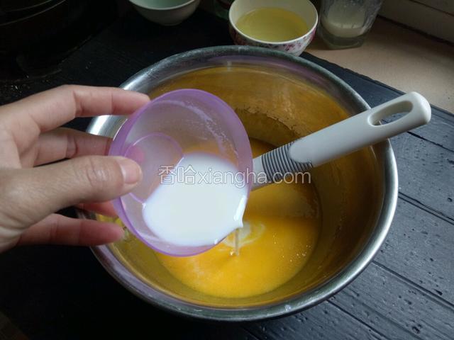 把牛奶倒入打好的蛋黄中，用手动打蛋器搅拌均匀。
