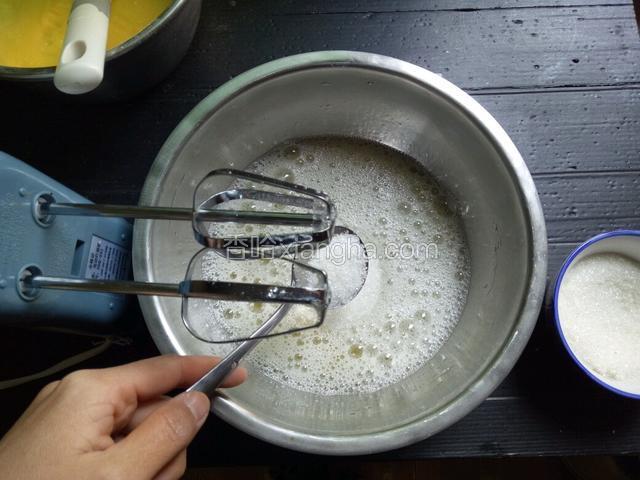 打至起鱼眼泡时加入1/3的白糖，继续打发。