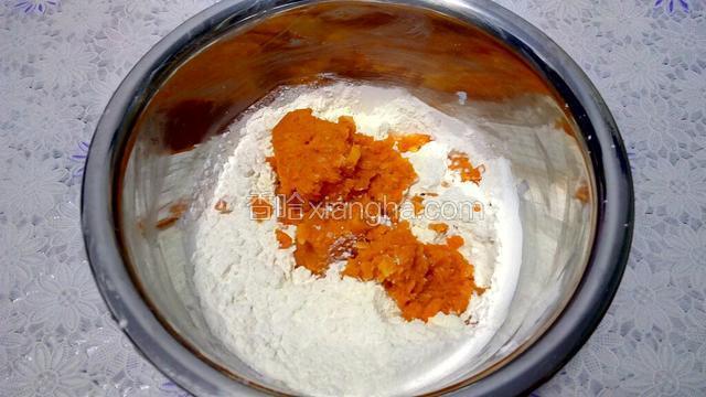 把胡萝卜泥放入盛糯米粉的盆中。