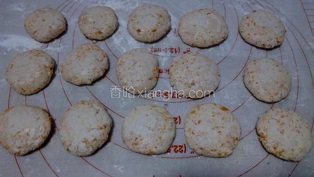 将面块用手搓圆，再压扁，放在面板上，如图。