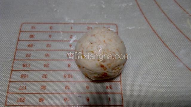 包好后，用双手轻轻将其搓成圆球状，放在面板上，如图。一个汤圆坯做好了。