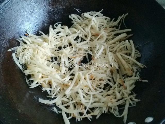 加入适量底油，煸炒干红辣椒变色后，加入饼丝；
