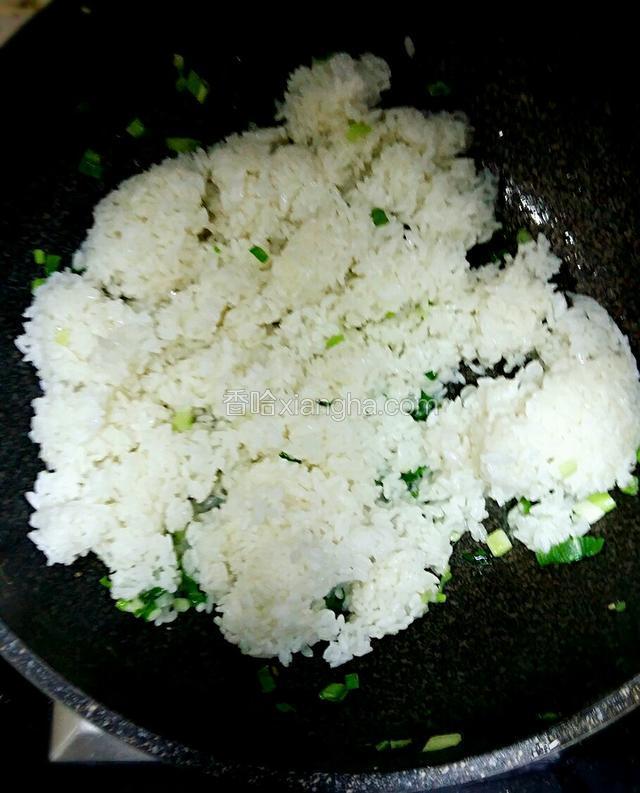 青菜炒塌后盛起，锅中再倒入适量的清油，爆香葱花后倒入米饭。喷少量的开水翻炒松碎。