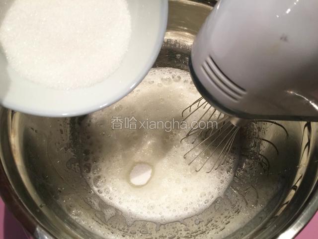 在蛋清内加入几滴柠檬汁，用电动打蛋器搅打至蛋白泡沫呈鱼泡眼状时，加入1/3细砂糖；